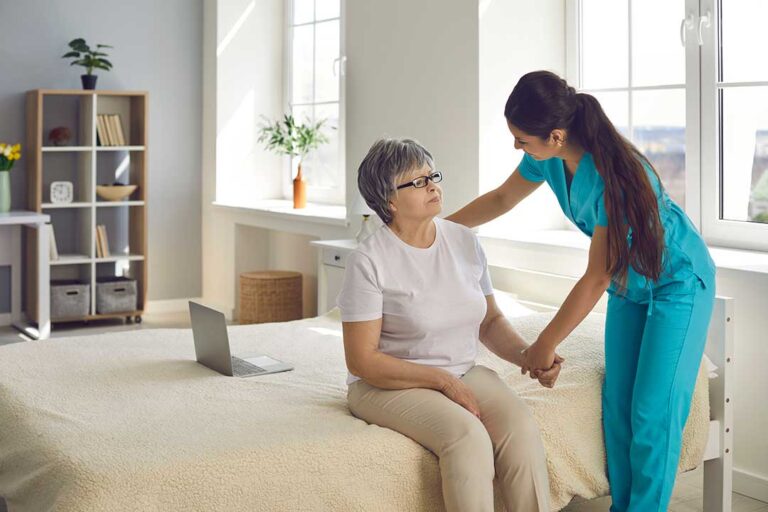 Family members and friends visiting an elderly resident in a cozy assisted living common room.