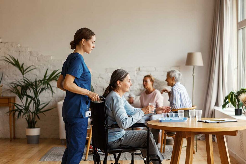 An older adult and family member sorting belongings and packing boxes in a cozy living room.