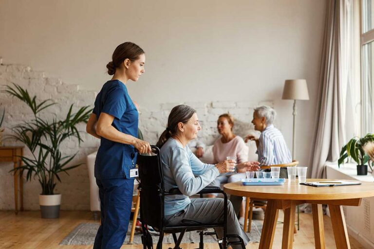 An older adult and family member sorting belongings and packing boxes in a cozy living room.